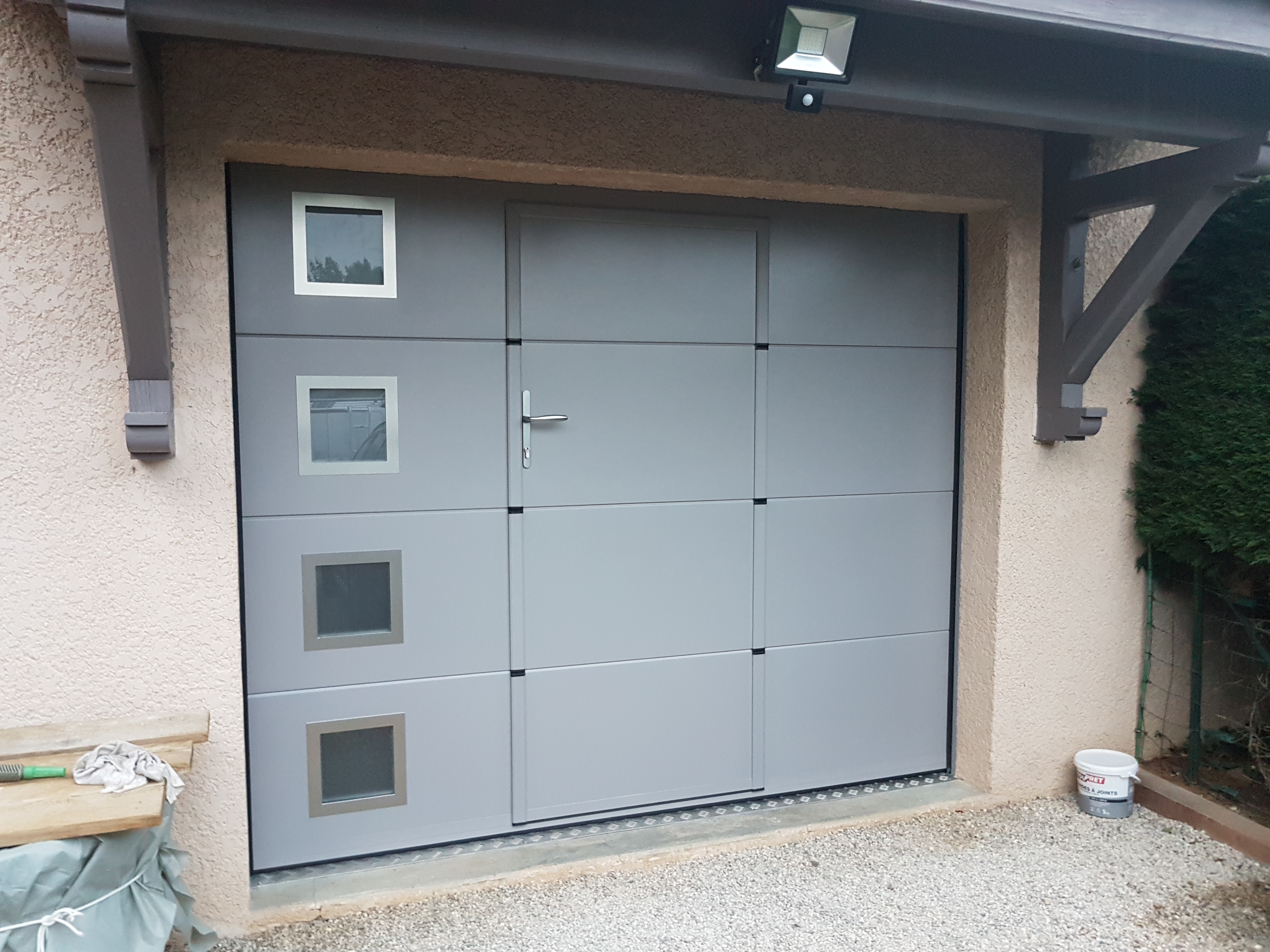 Porte de garage sectionnelle vitrée installée par THERA Fermetures